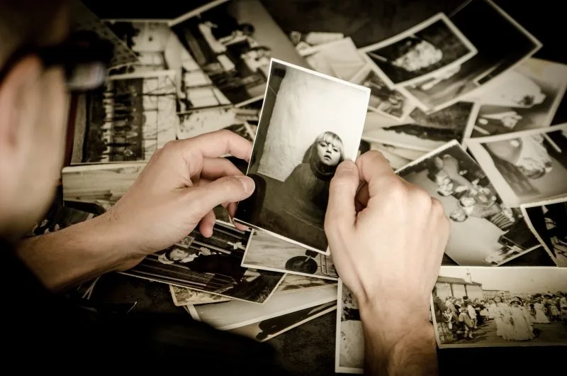 Hands sorting a collection of old photographs